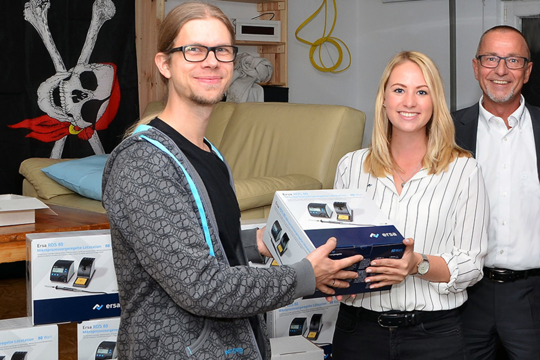 Ersa Tools Sales Manager Hansjürgen Bolg (right) and Key Account Manager Katharina Fertig hand over soldering stations to Schaffenburg e.V., Andreas Frisch accepts them on behalf of Schaffenburg e.V.