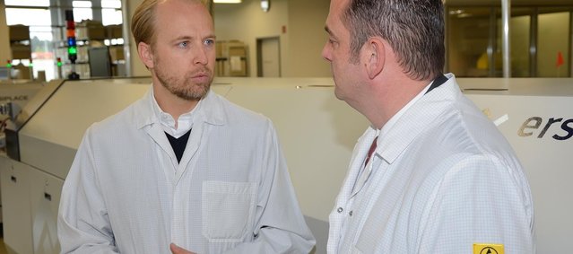 Managing Director Alexander Sorg (left) and Ersa Area Sales Manager Radek Lauer talking in front of the Ersa HOTFLOW 3/20 reflow system installed at the end of 2016